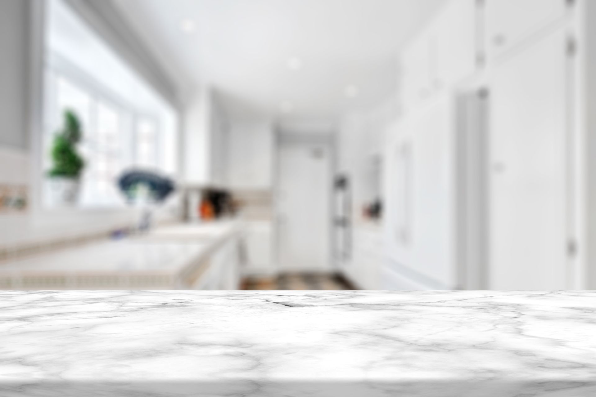 There is a marble table in the foreground and a kitchen in the background.