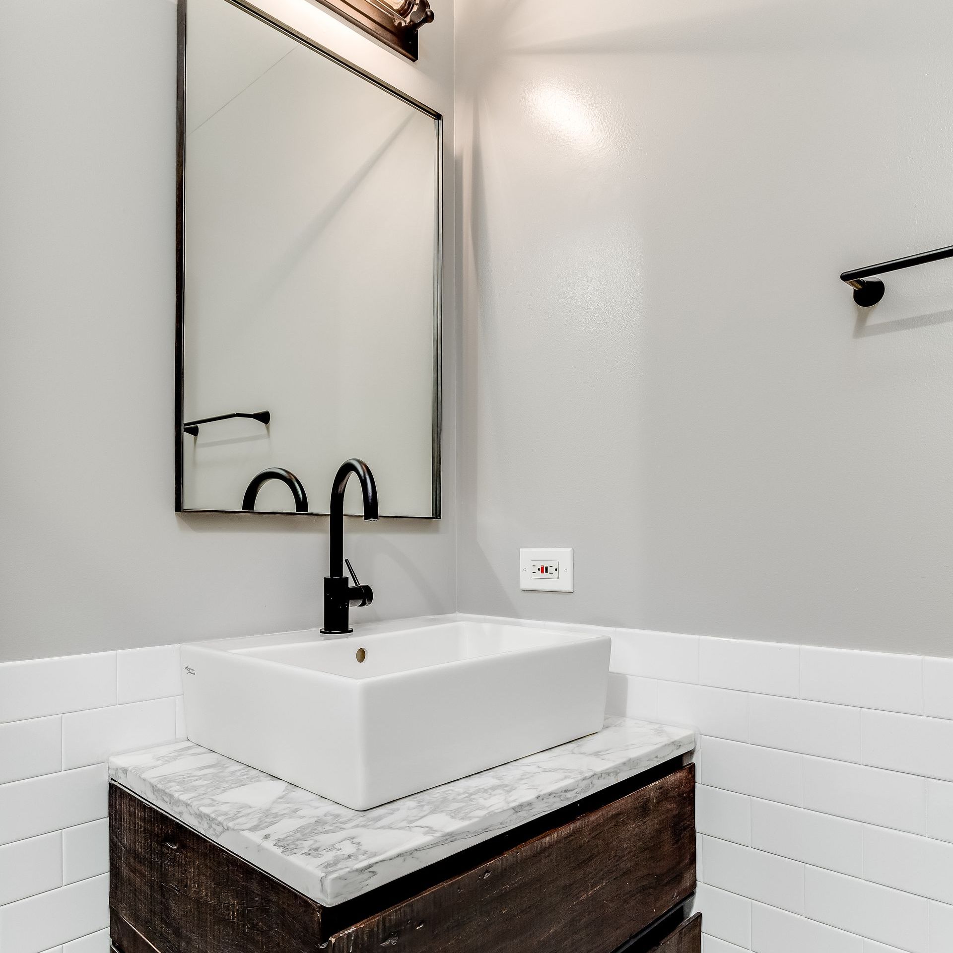 A bathroom with a sink and a mirror on the wall