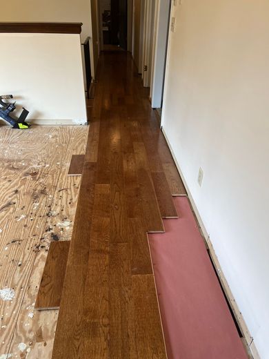 A hallway with a wooden floor being installed