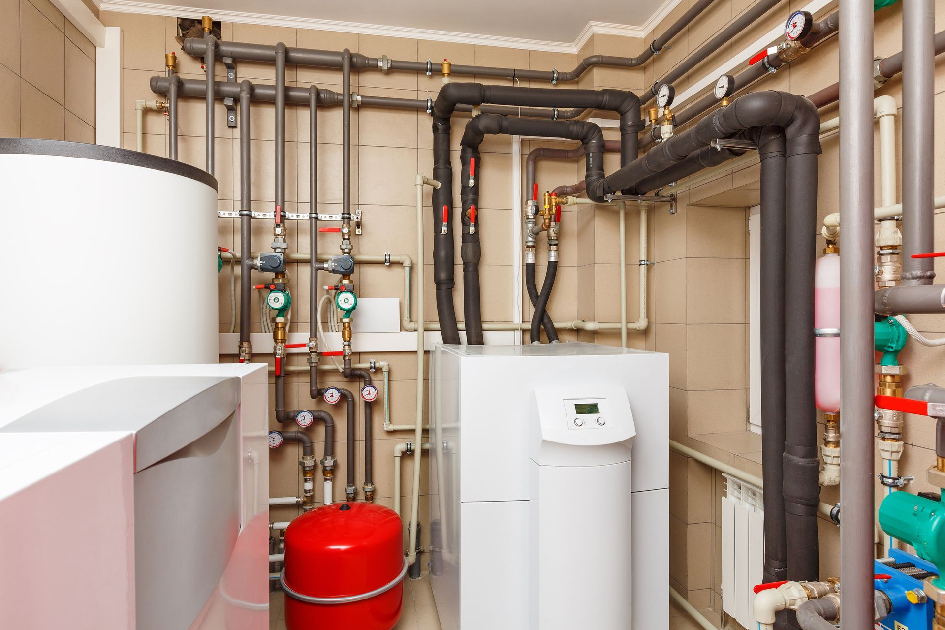 A room with a water heater and a lot of pipes.