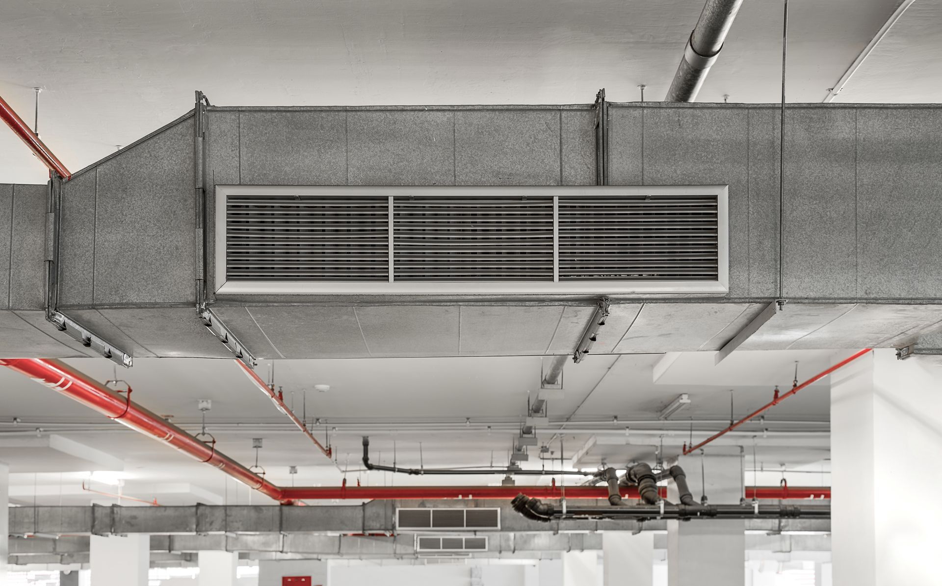 A large air duct is hanging from the ceiling of a building.