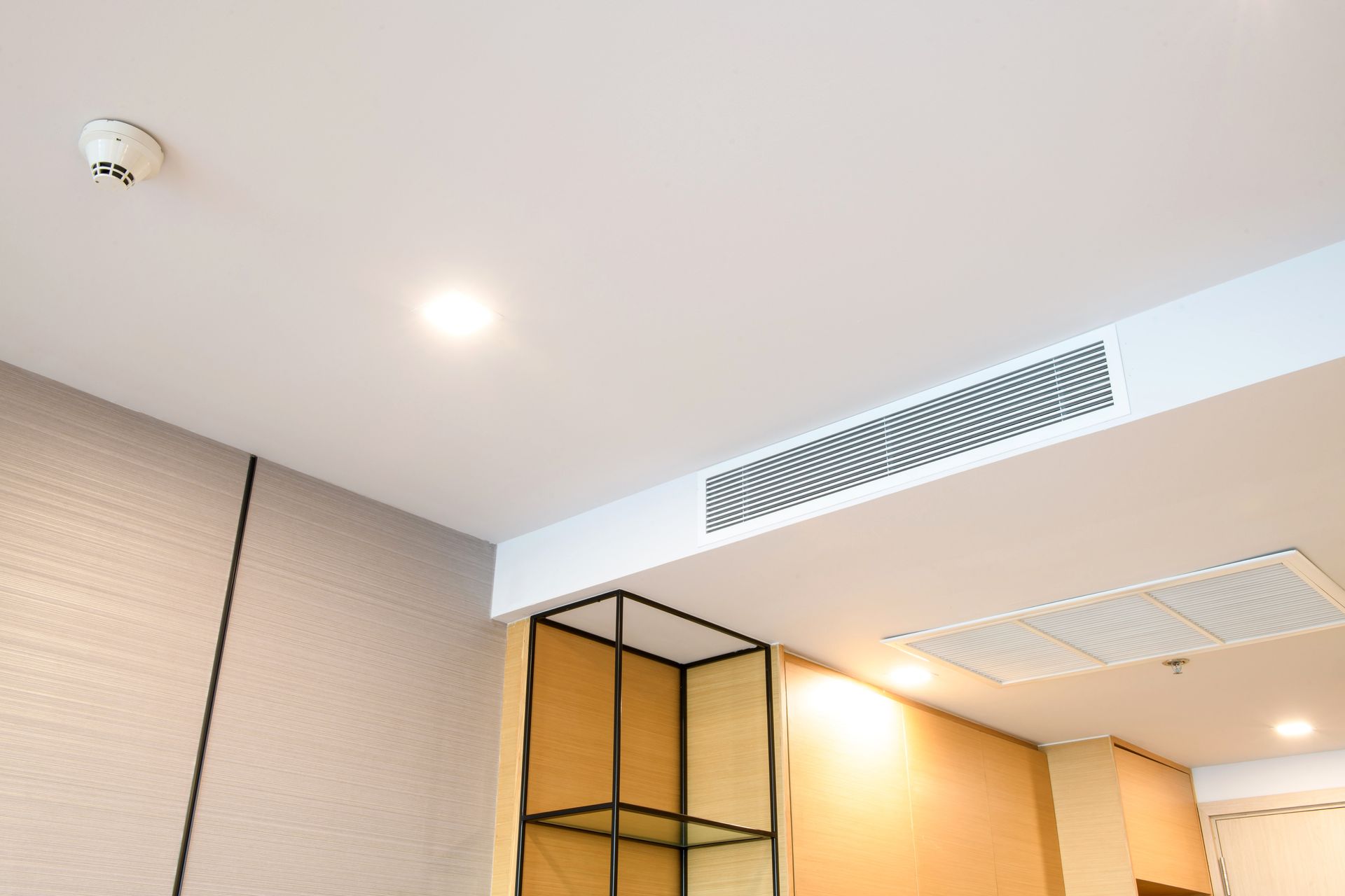 A room with a ceiling fan and a fire alarm on it.