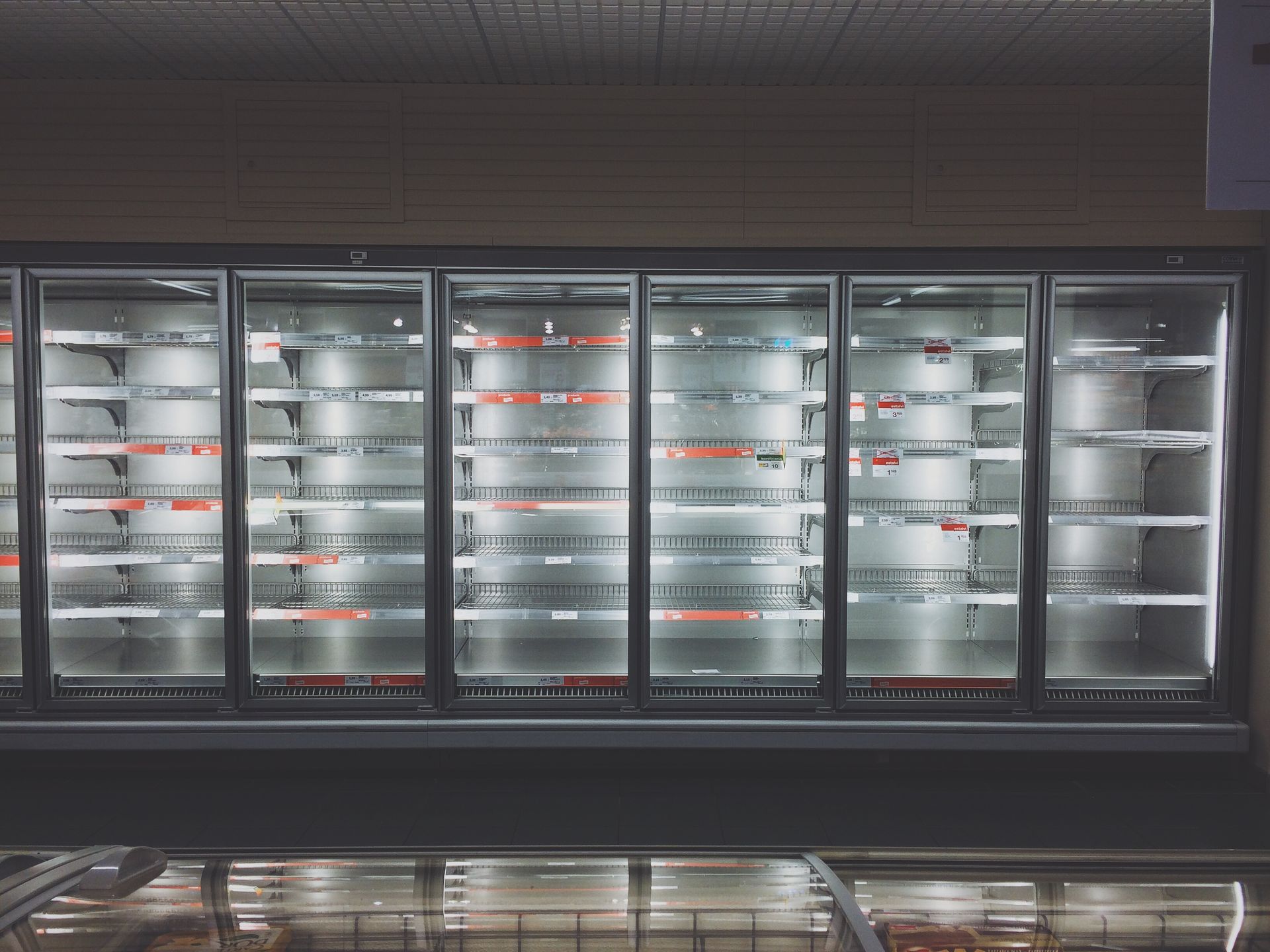 A row of empty refrigerators in a grocery store.