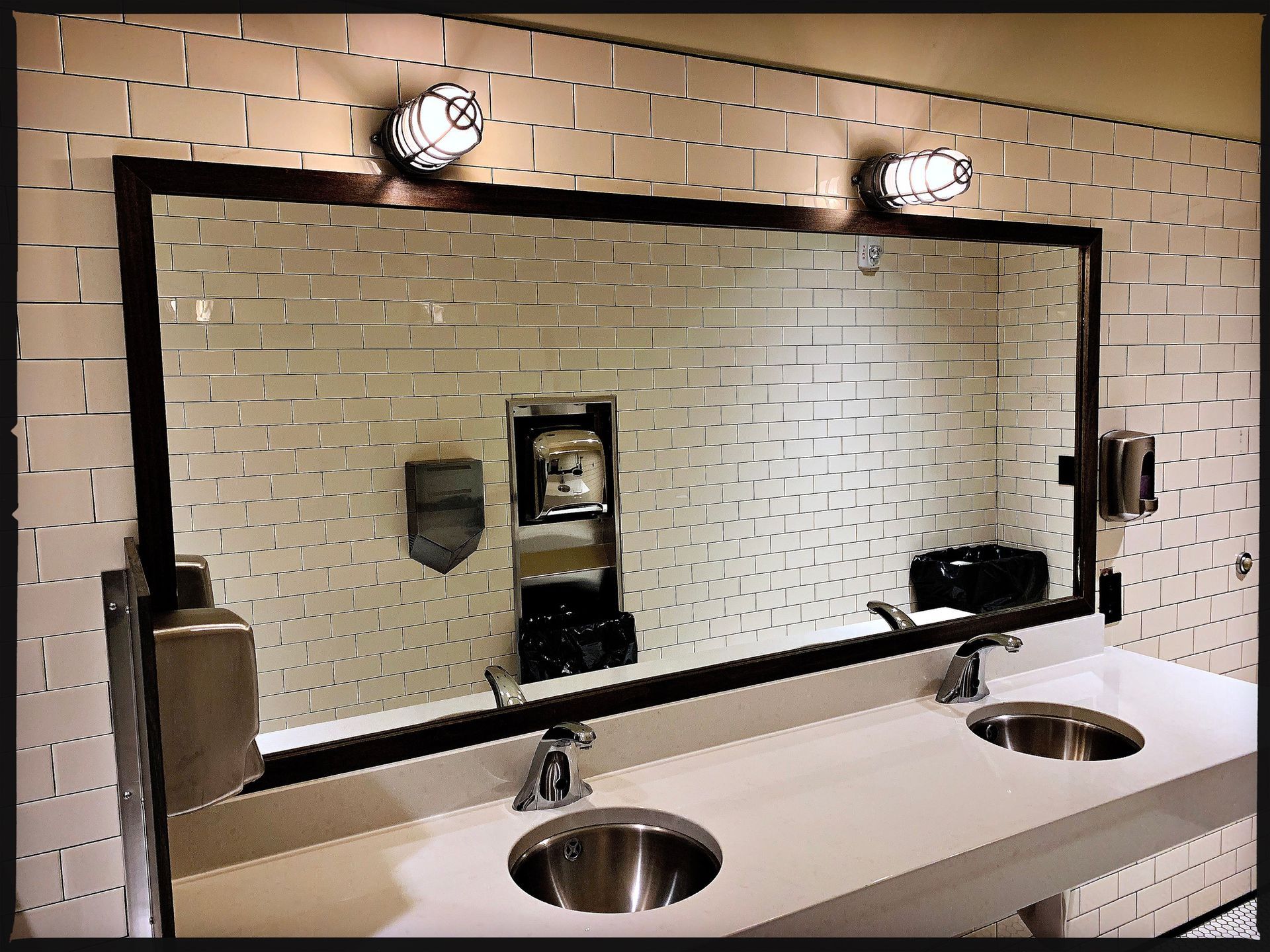A bathroom with two sinks and a large mirror