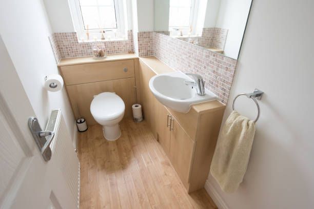 A small bathroom with a toilet , sink and mirror.