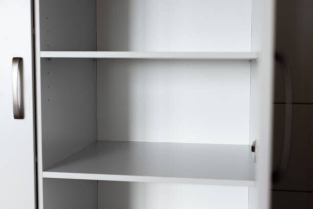 A white shelf with three shelves and a door.