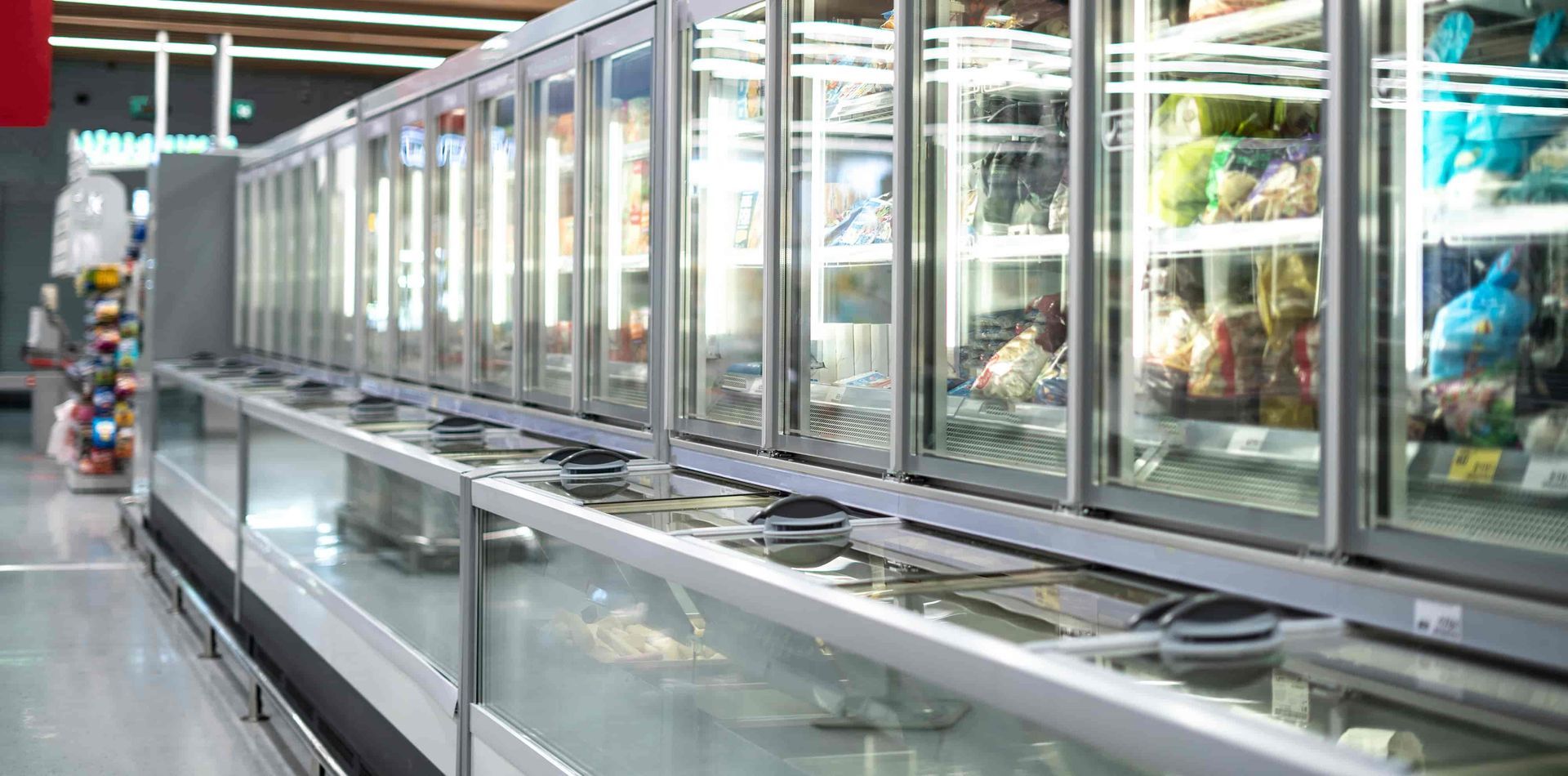 A long row of refrigerated glass doors at a grocery store. — Allchin Airconditioning & Refrigeration Electrical in Caloundra, QLD