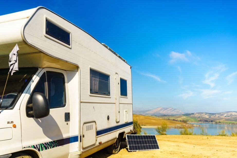 White Rv Parked on A Sandy Area with A Solar Panel — Allchin Airconditioning & Refrigeration Electrical in Caloundra, QLD