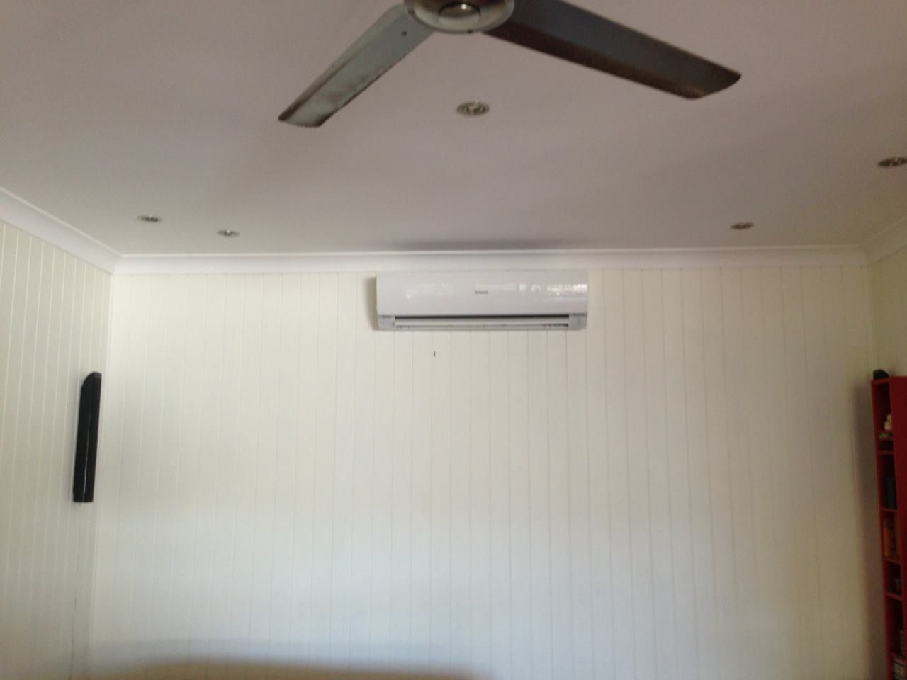 White Room with An Air Conditioner, Ceiling Fan, and Panelled Walls — Allchin Airconditioning & Refrigeration Electrical in Caloundra, QLD