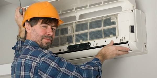 Man Wearing a Hard Hat Working on An Air Conditioning Unit — Allchin Airconditioning & Refrigeration Electrical in Caloundra, QLD