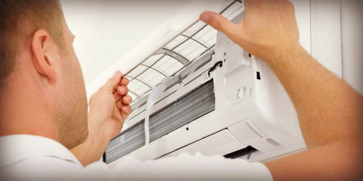 A Person Removing an Air Conditioner Filter — Allchin Airconditioning & Refrigeration Electrical in Caloundra, QLD