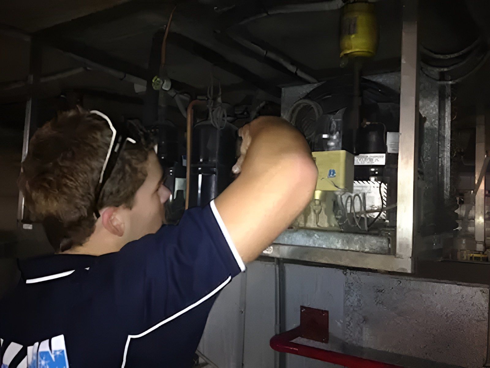 A Man Is Fixing a Refrigerator in A Camper — Allchin Airconditioning & Refrigeration Electrical in Caloundra, QLD