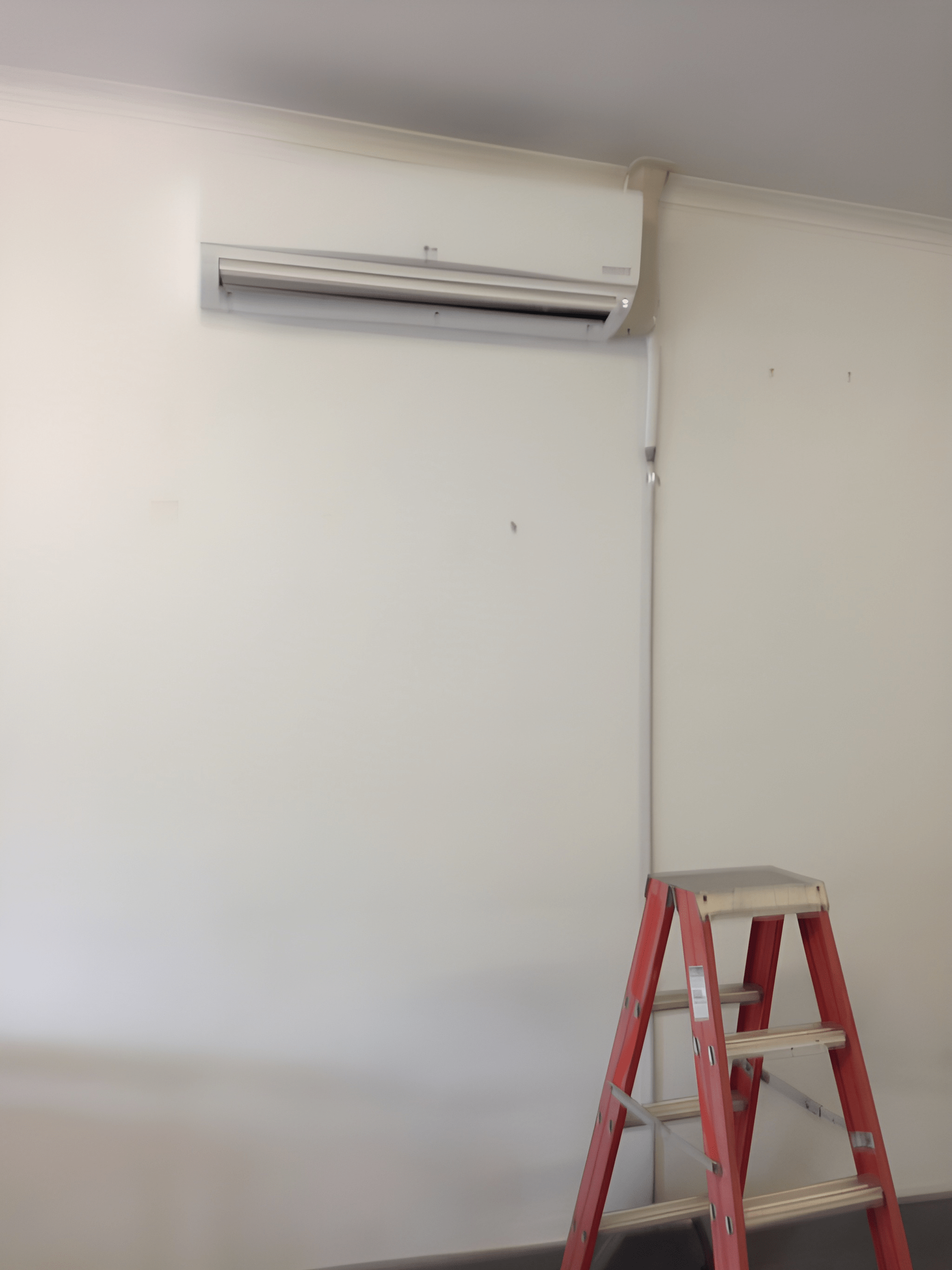 White Wall with A Mounted Air Conditioner — Allchin Airconditioning & Refrigeration Electrical in Caloundra, QLD