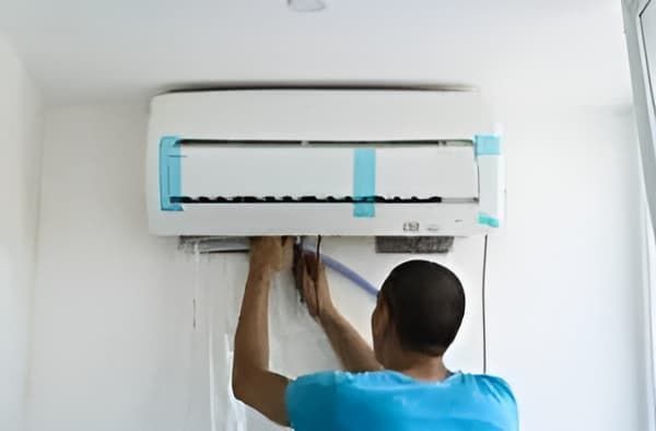 A Man Is Installing — Allchin Airconditioning & Refrigeration Electrical in Caloundra, QLD