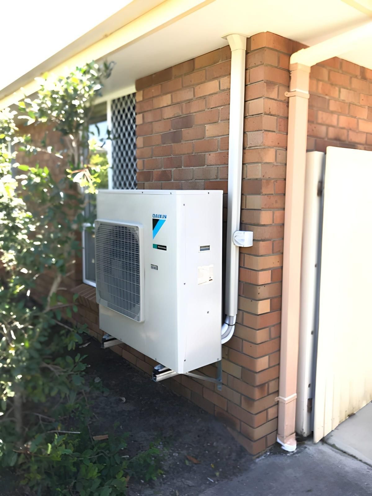 A White Daikin Air Conditioner Mounted on A Brick Wall — Allchin Airconditioning & Refrigeration Electrical in Caloundra, QLD