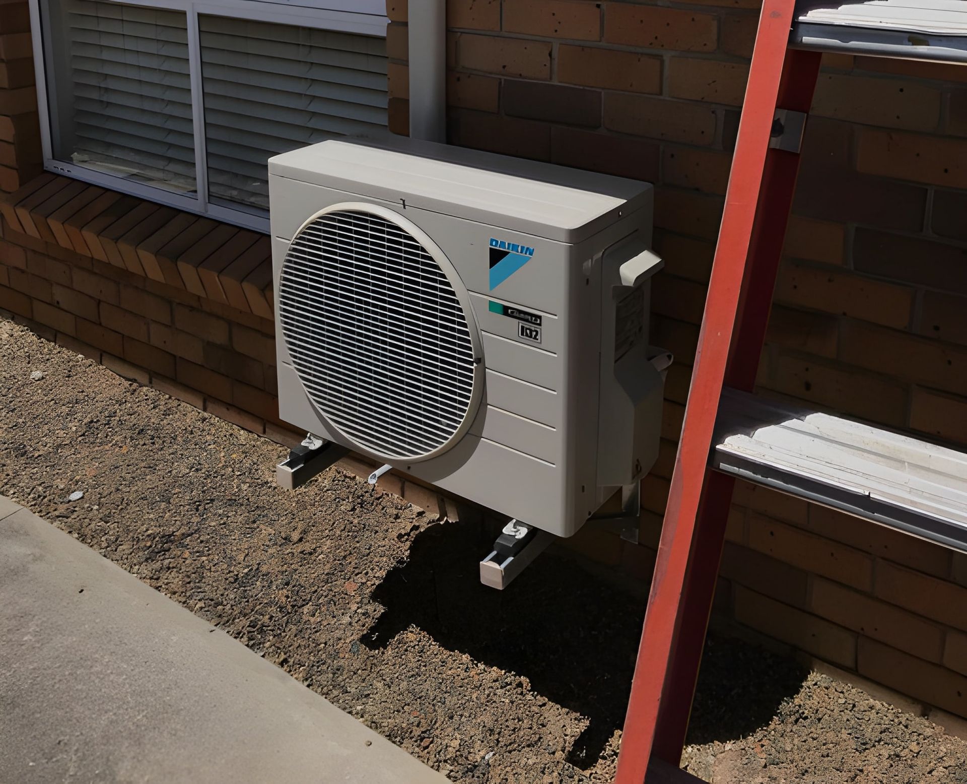 Gray Air Conditioner Unit Mounted on A Brick Wall — Allchin Airconditioning & Refrigeration Electrical in Caloundra, QLD