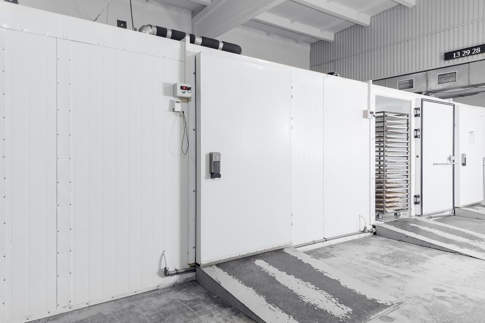 Large white industrial refrigerator with multiple doors, loading ramp, and interior racks. — Allchin Airconditioning & Refrigeration Electrical in Caloundra, QLD