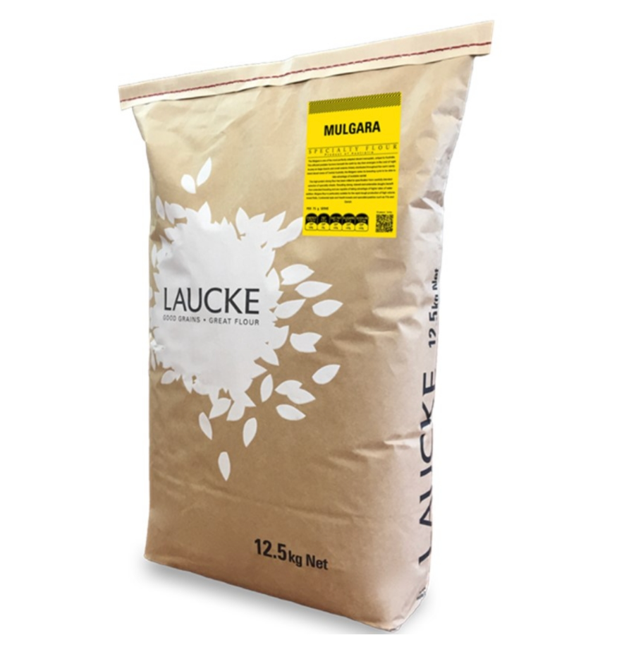 Man Preparing Bread Dough on Wooden Table in a Bakery Close Up — Local Bakery Wholesaler in Ballarat, VIC