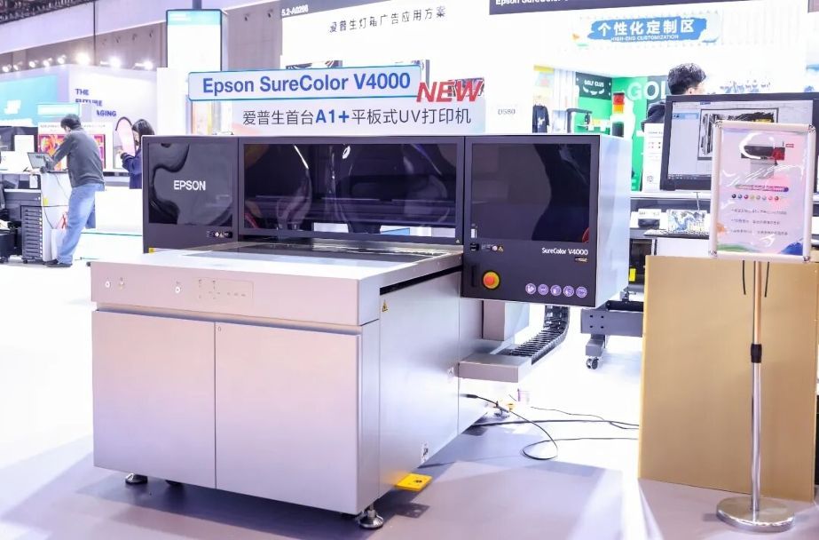 Epson SureColor V4000 este o imprimantă UV flatbed cu 10 culori UltraChrome, format 980×700mm, grosime suport 200mm. Ideală pentru semnalistică și personalizare pe acril, metal, lemn. Design compact, senzor laser auto, cerneală albă și lac incluse. Segment mid-range.