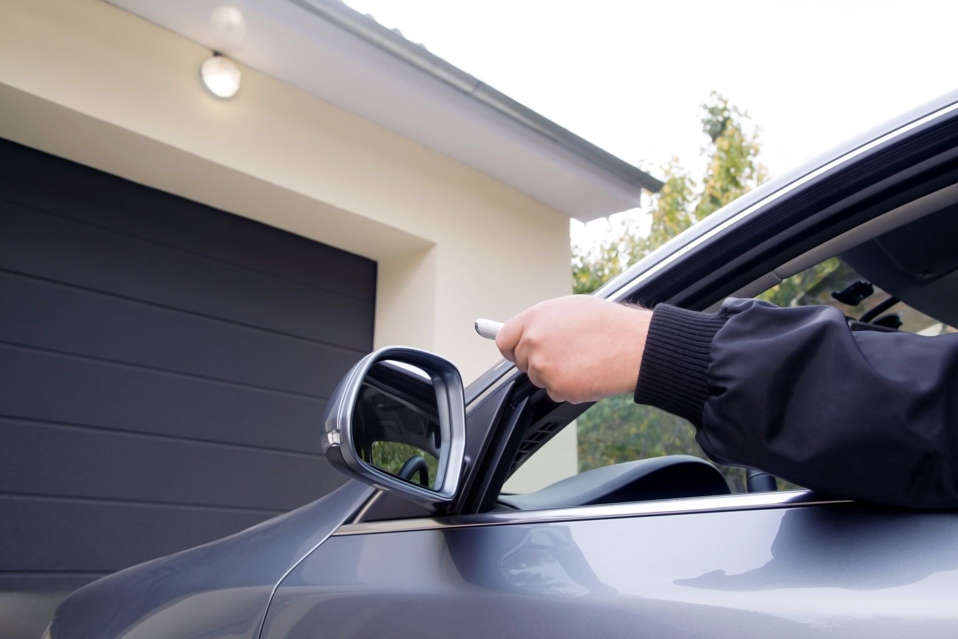 Man using a remote control to open a garage door.