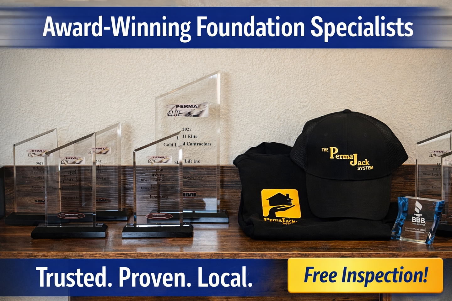 A wooden table displaying awards, a black baseball cap with logo, and a black shirt, with 