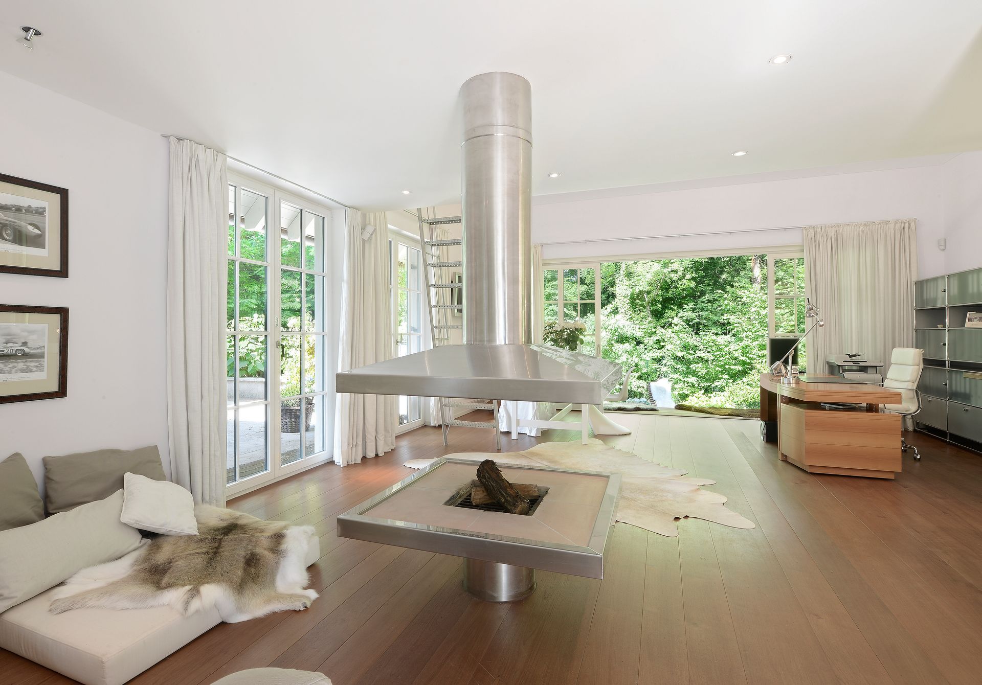 Modern living room with fireplace, white walls, sliding glass doors to a lush garden.