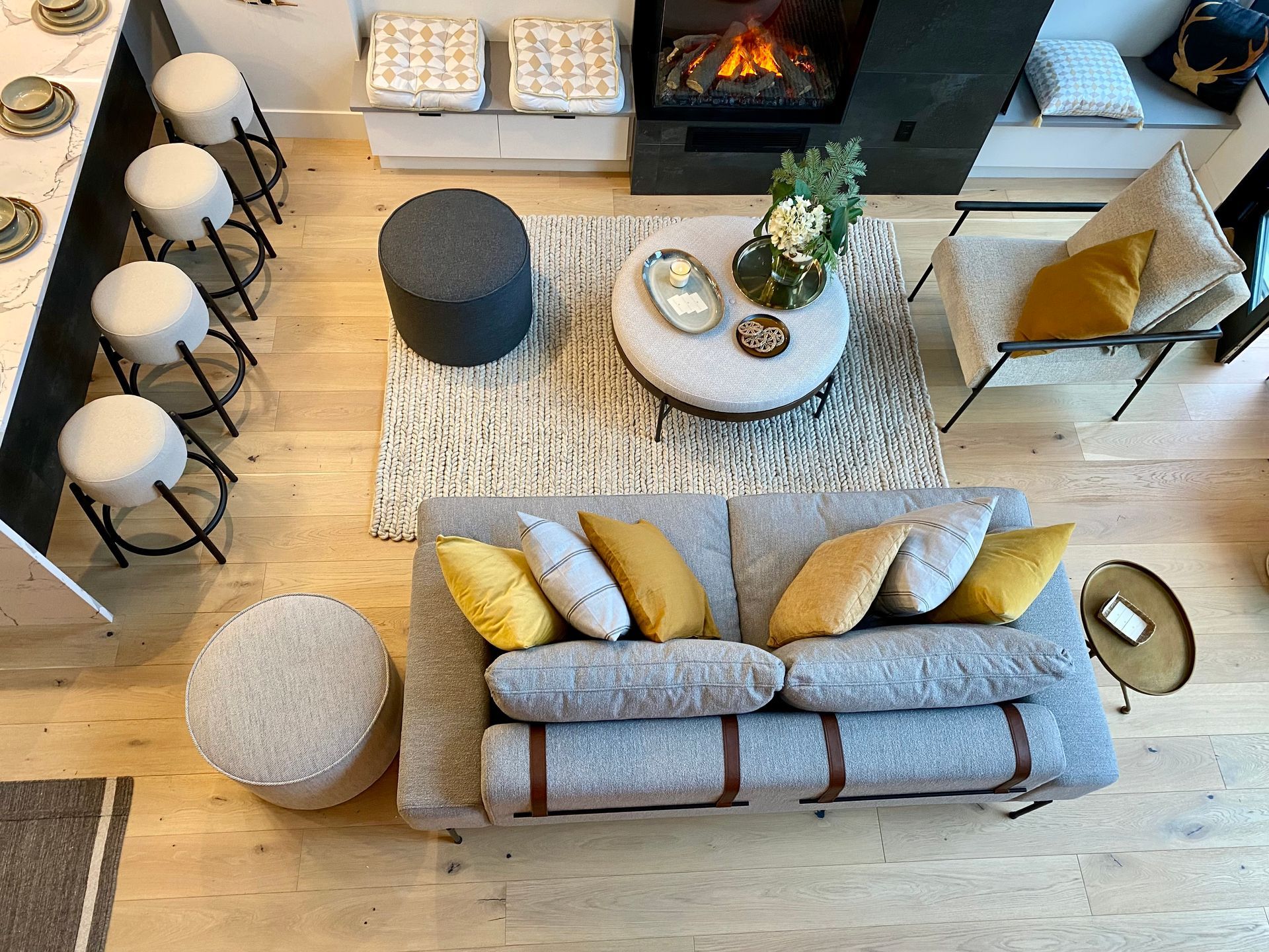 Overhead view of a modern living room with a sofa, rug, chairs, and fireplace.