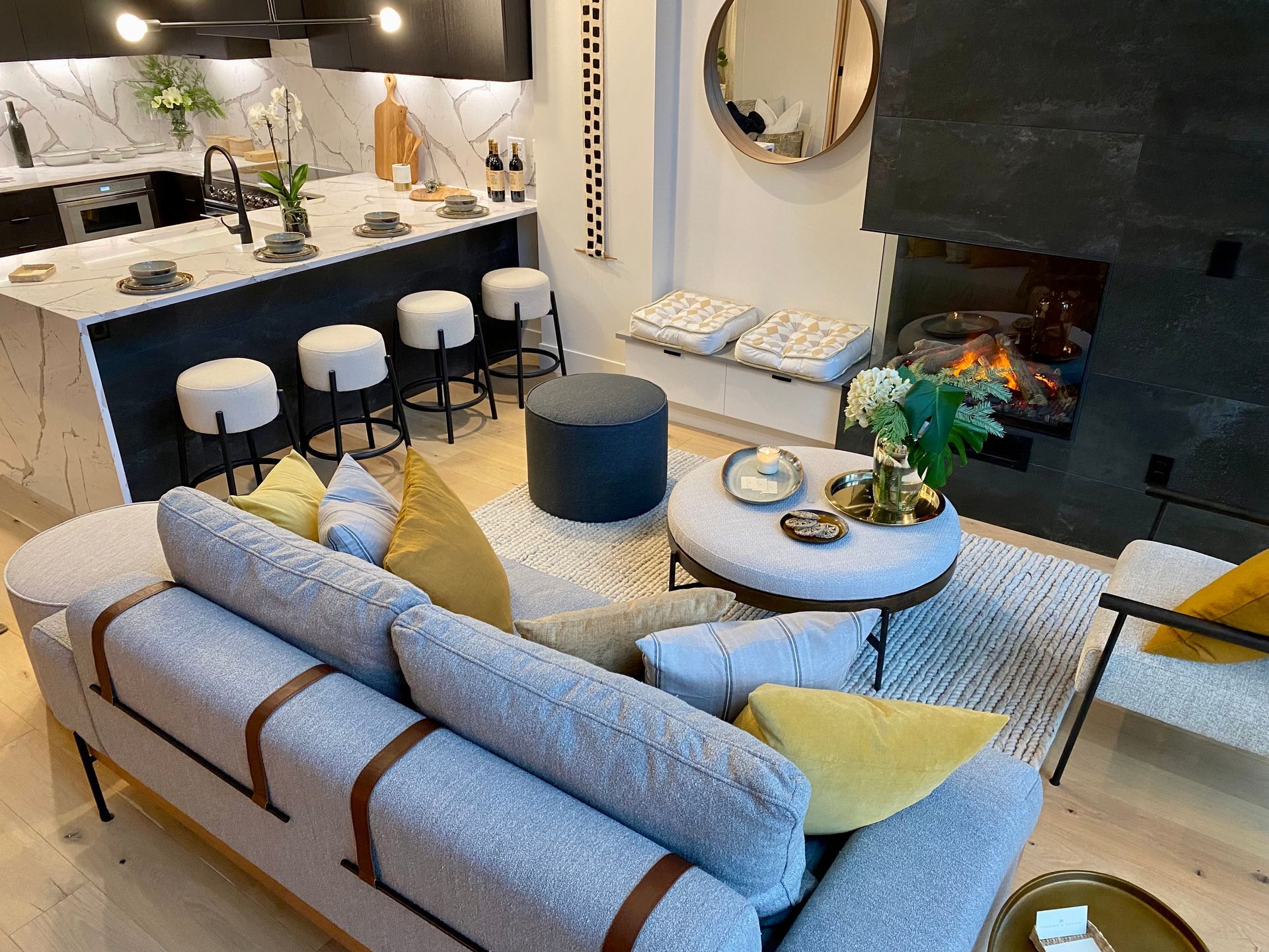 Modern living room with a kitchen island, sofa, and fireplace.