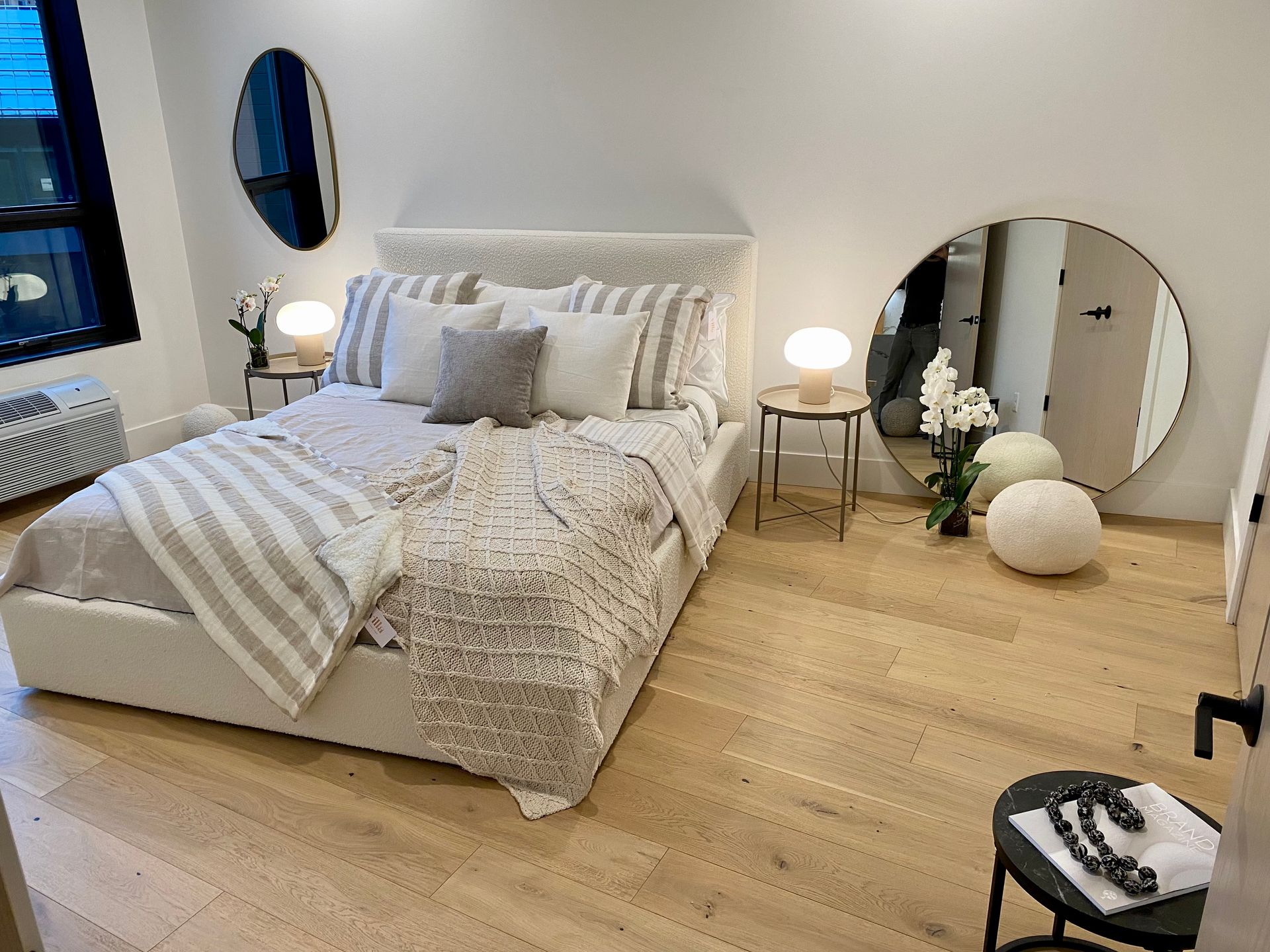 Bedroom with a bed, mirrors, side tables, and decorative items.