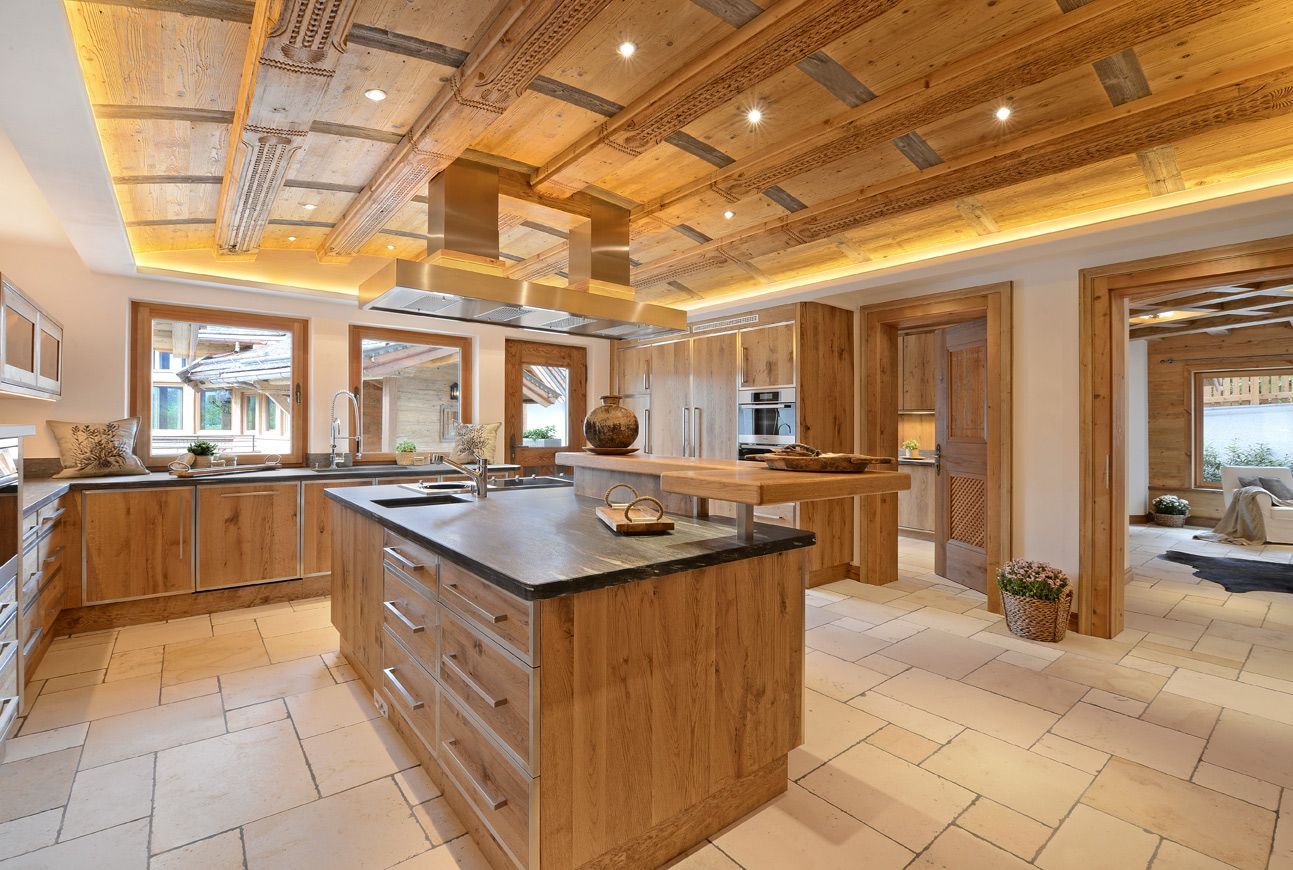 Wooden kitchen with island, cabinets, and a decorative ceiling. Light beige floor, neutral tones.
