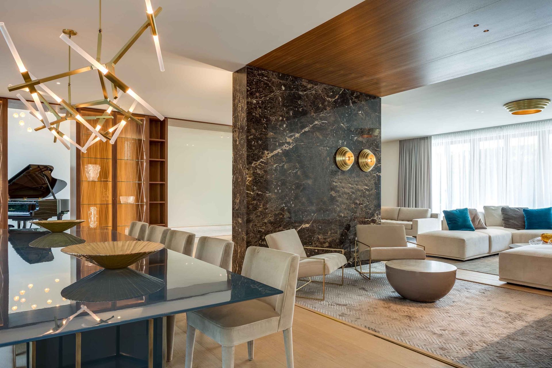 Luxurious interior: dining table, living area with sofa, marble accent wall, grand piano.