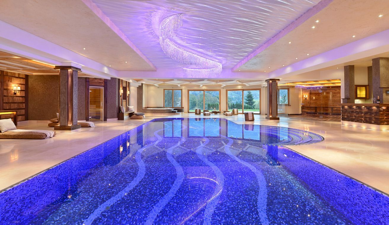 Indoor swimming pool with mosaic tile and starry ceiling lights.
