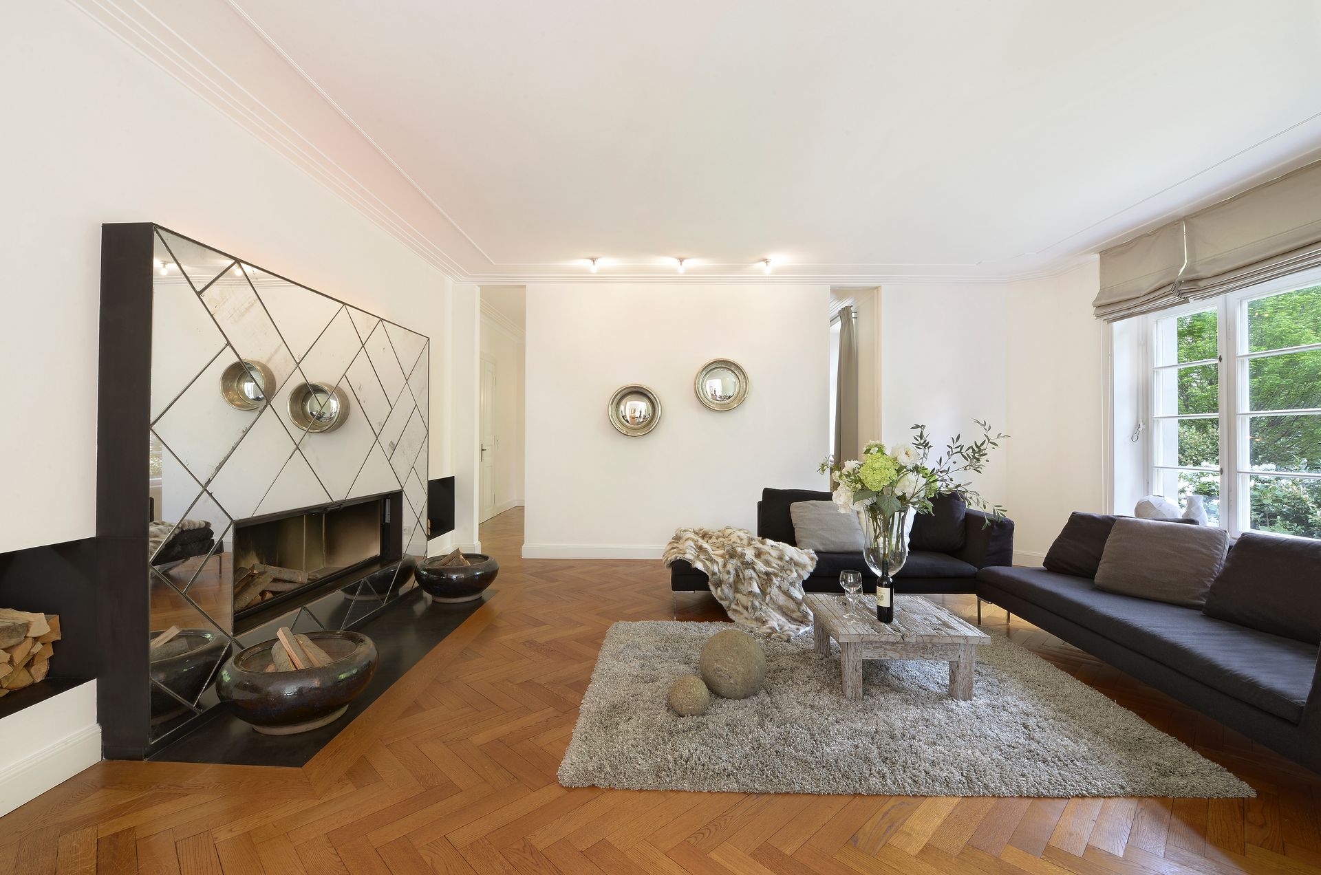 Living room with a fireplace, dark furniture, and a rug on a hardwood floor.
