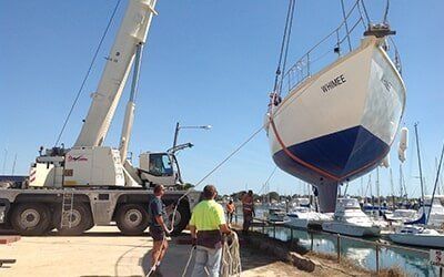 A Boat Is Being Lifted Into The Water By A Crane — S & W Crane Hire In Bowen, QLD