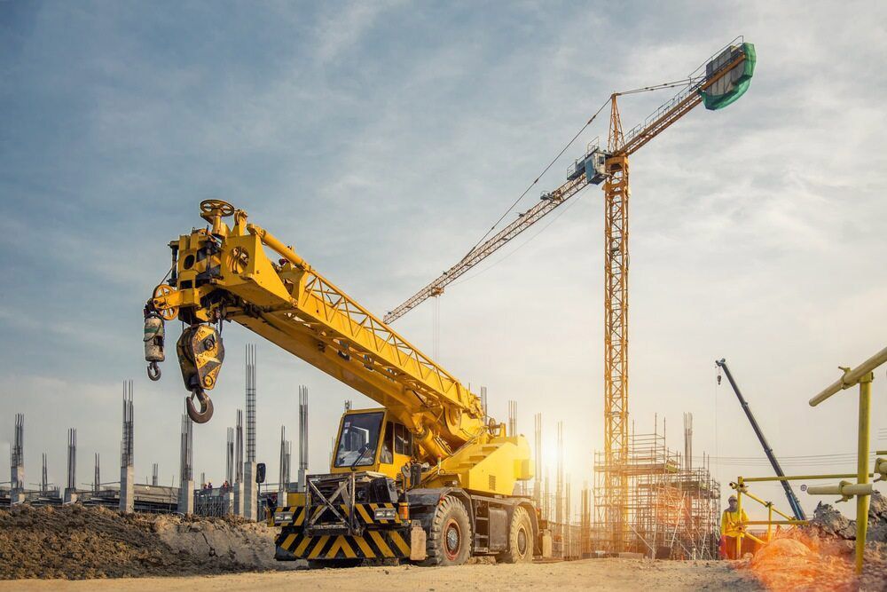 A Yellow Crane Is Sitting On Top Of A Construction Site — S & W Crane Hire In Collinsville, QLD