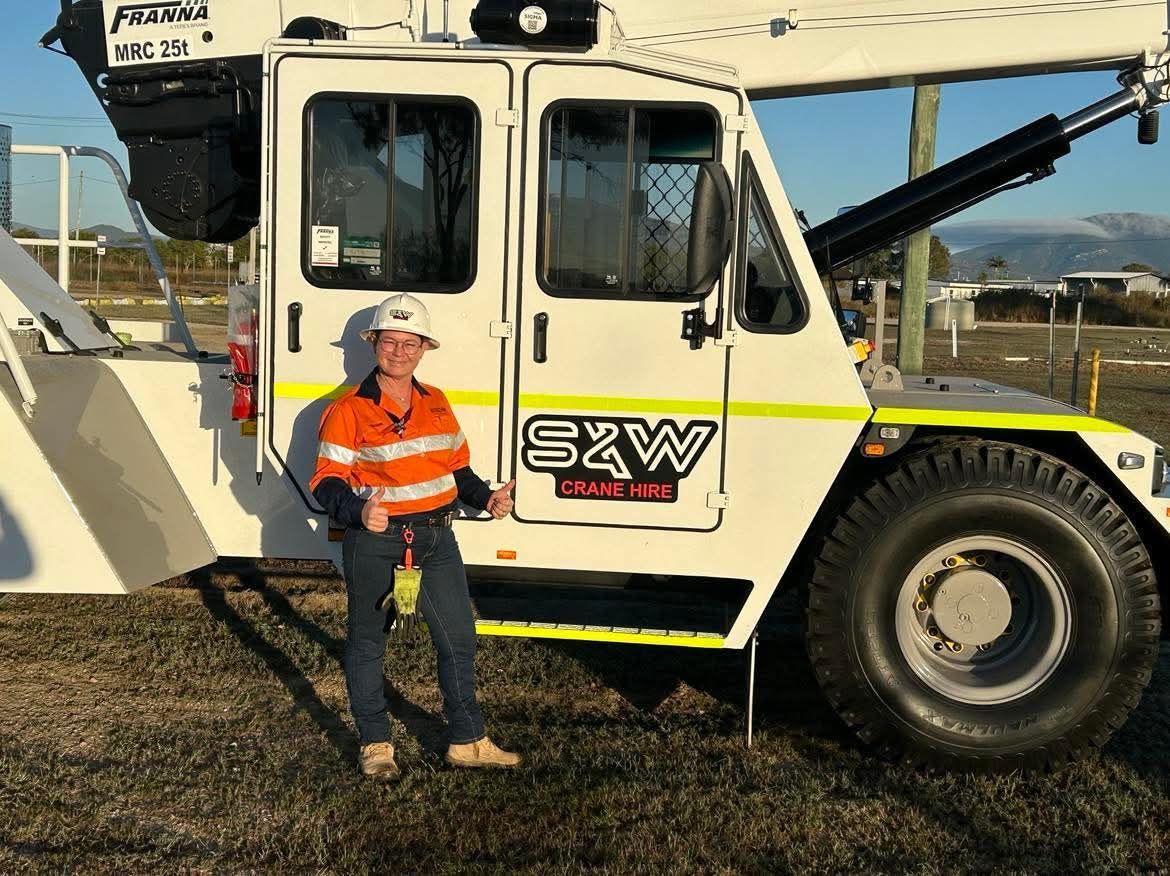 A man is standing in front of a truck that says s2w on it — S & W Crane Hire In Bowen, QLD