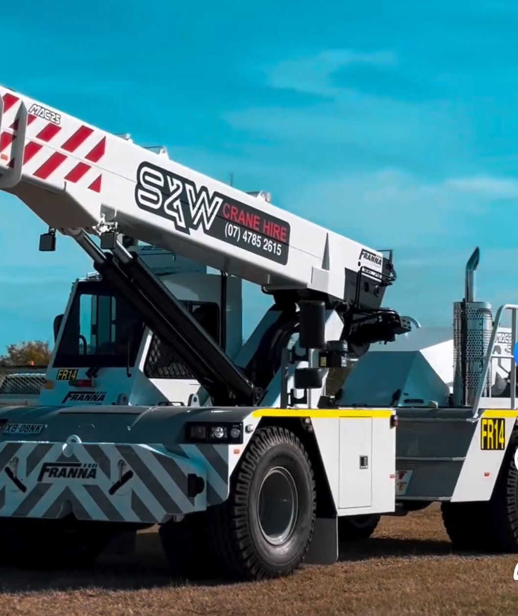 A Large White Truck With A Crane On The Back Is Parked On The Side Of The Road — S & W Crane Hire In Bowen, QLD