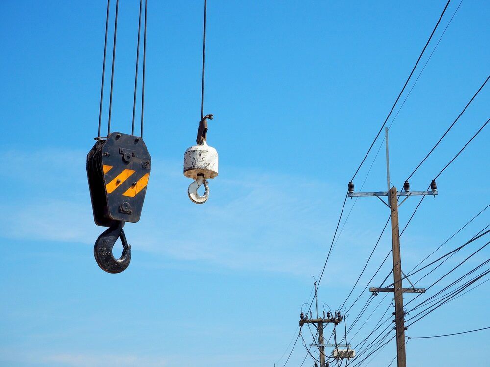 A Crane Hook Is Hanging From A Power Line — S & W Crane Hire In Whitsundays, QLD
