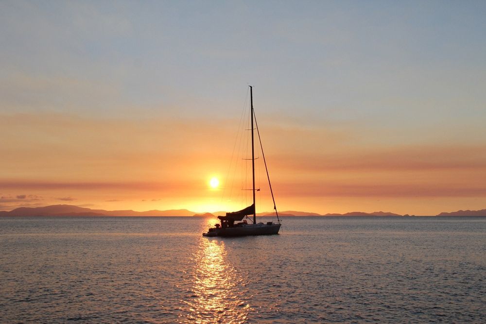 A Sailboat In The Middle Of The Ocean At Sunset — S & W Crane Hire In Collinsville, QLD