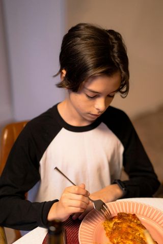 An elderly woman is helping a young boy with his homework.