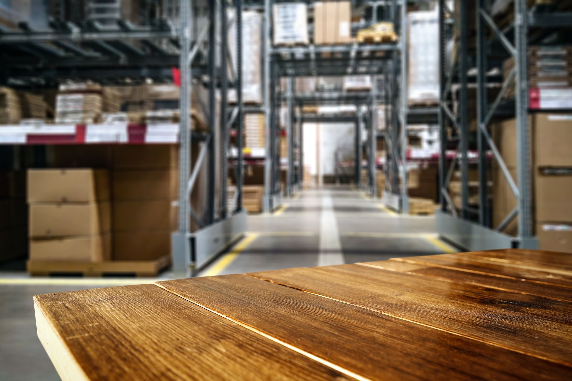 Blurred warehouse aisle with shelves and boxes in the background.