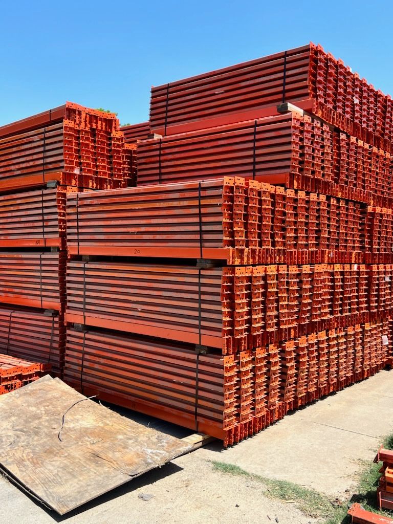 A large stack of red scaffolding is sitting on the ground.
