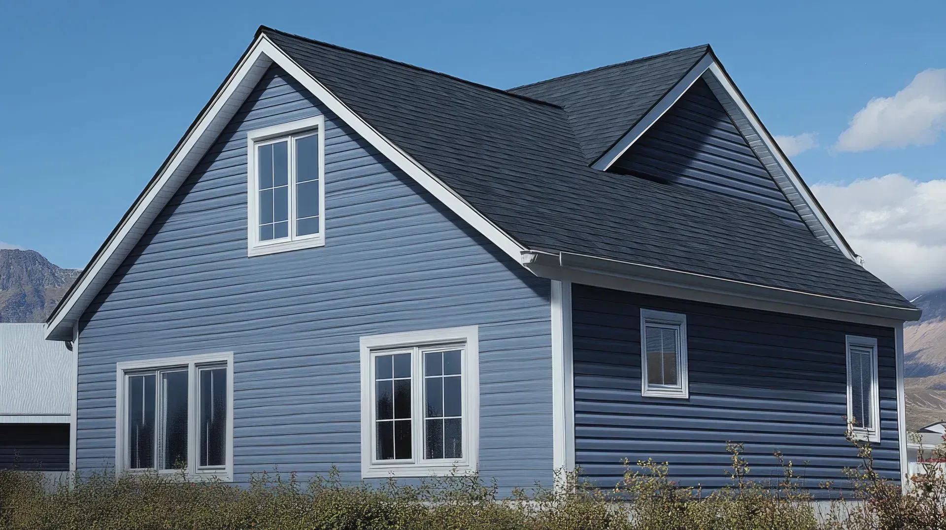 A blue house with a black roof and white trim
