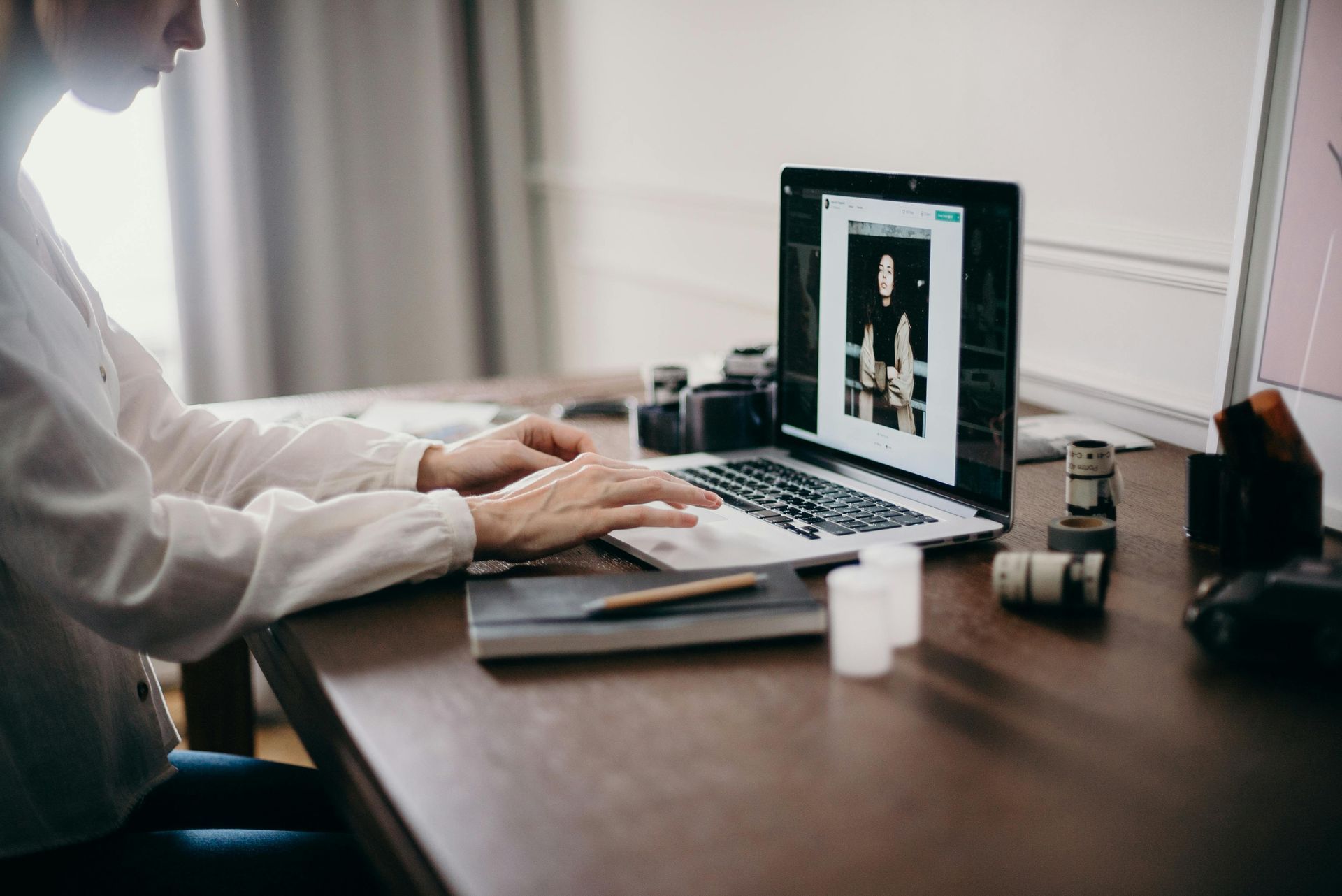 A man is sitting at a desk in front of three computer monitors.