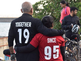 Long-term partners sporting “Together 1995” jerseys at an outdoor couples coaching event