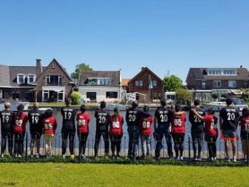 Participants of couples coaching in Europe posing in matching jerseys beside a Dutch canal