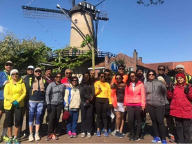 Couples coaching in Europe group shot under a classic windmill during an excursion