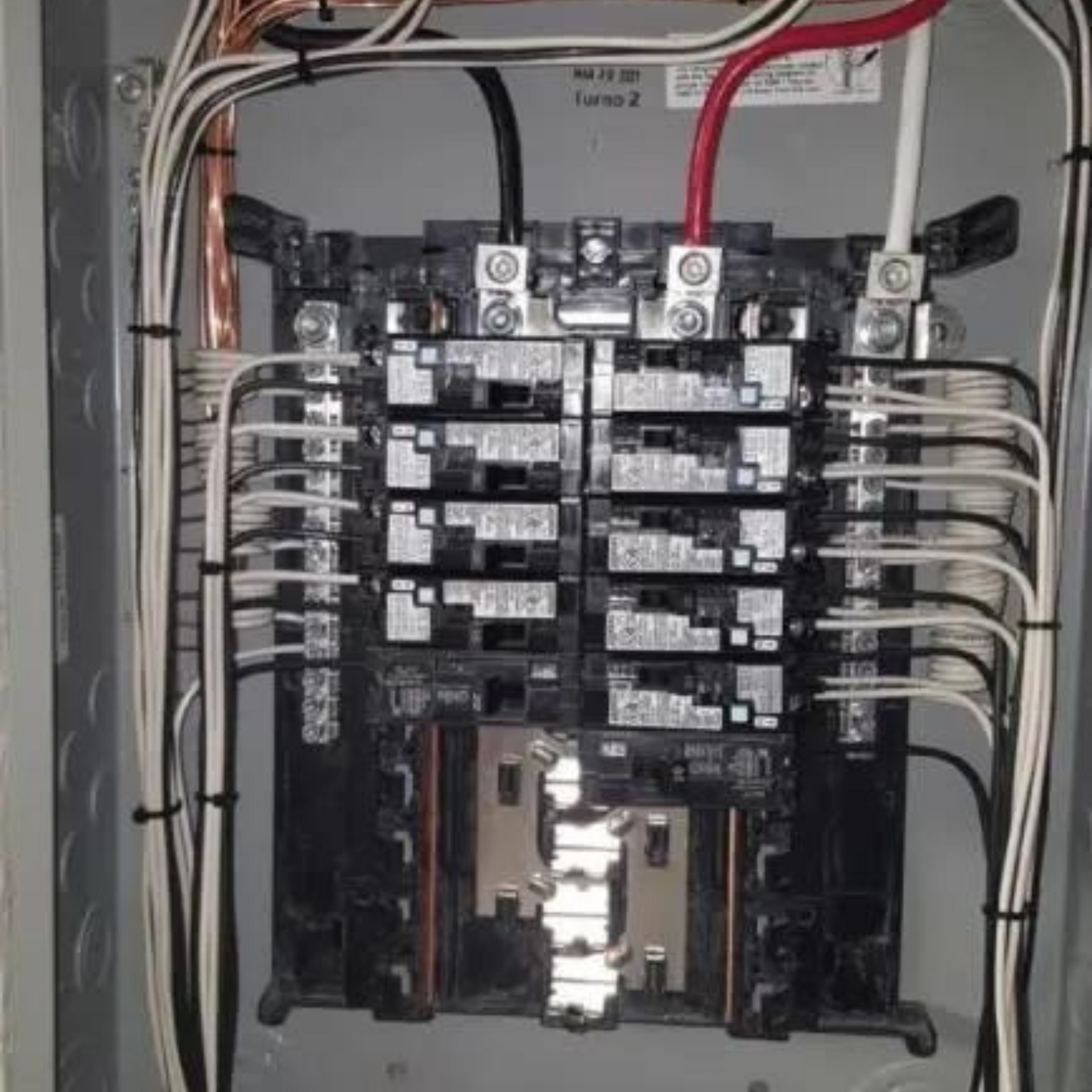 Michael Lawrence Electric Inc
- A close up of a electrical panel with a lot of wires coming out of it.