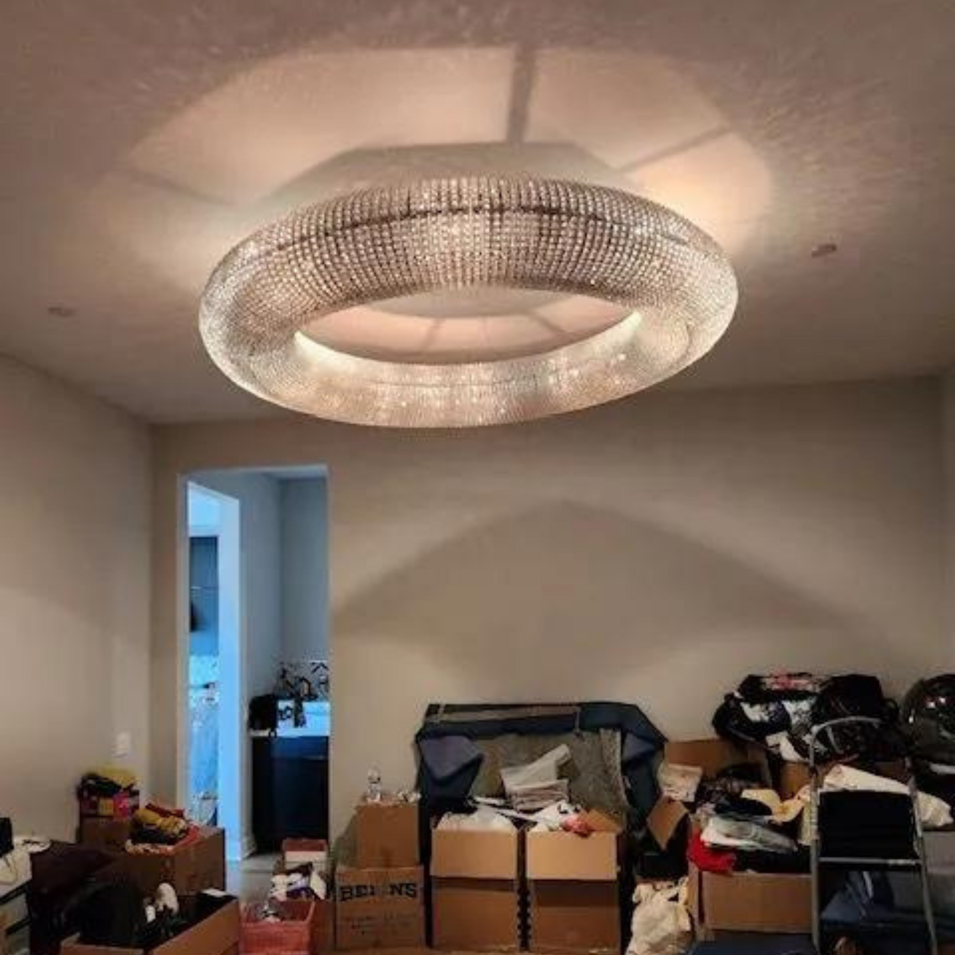 Michael Lawrence Electric Inc
-A living room filled with boxes and a large chandelier.