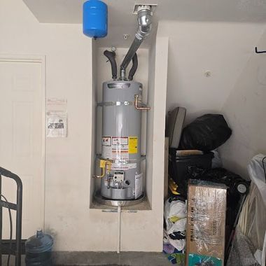 Water heater in a garage closet with pipes, a blue expansion tank, and storage items nearby.